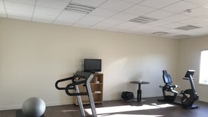 A fitness room with a treadmill, elliptical, stationary bike, and exercise ball. - Hotel Mercure Aix en Provence Sainte Victoire (Chateauneuf-le-Rouge)