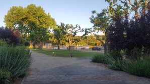 A gravel path leading to a fenced area with a pool and lounge chairs. - Hotel Mercure Aix en Provence Sainte Victoire (Chateauneuf-le-Rouge)