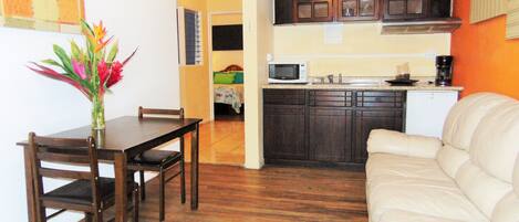 A compact living space with a dining area, kitchenette, and a sofa.