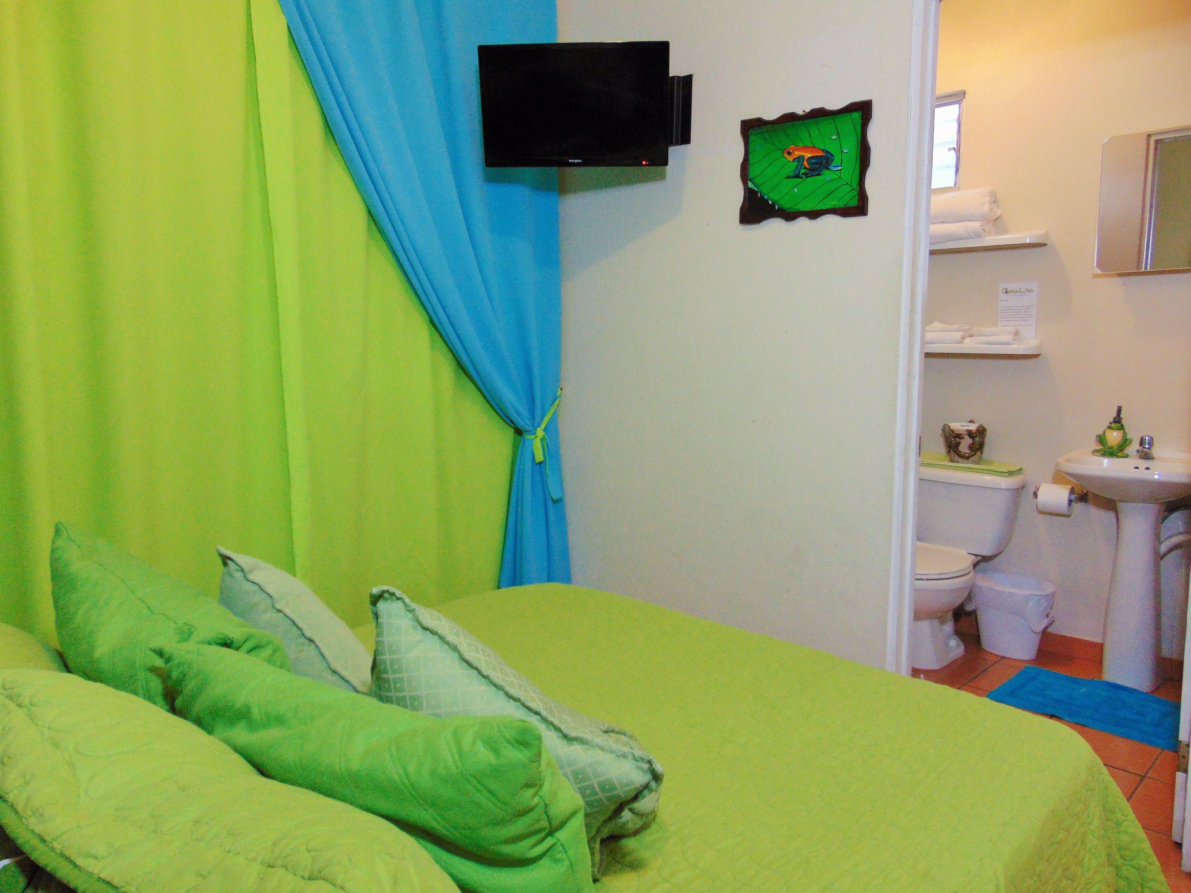 Ein Zimmer mit Bett, Fernseher, Toilette und Waschbecken.