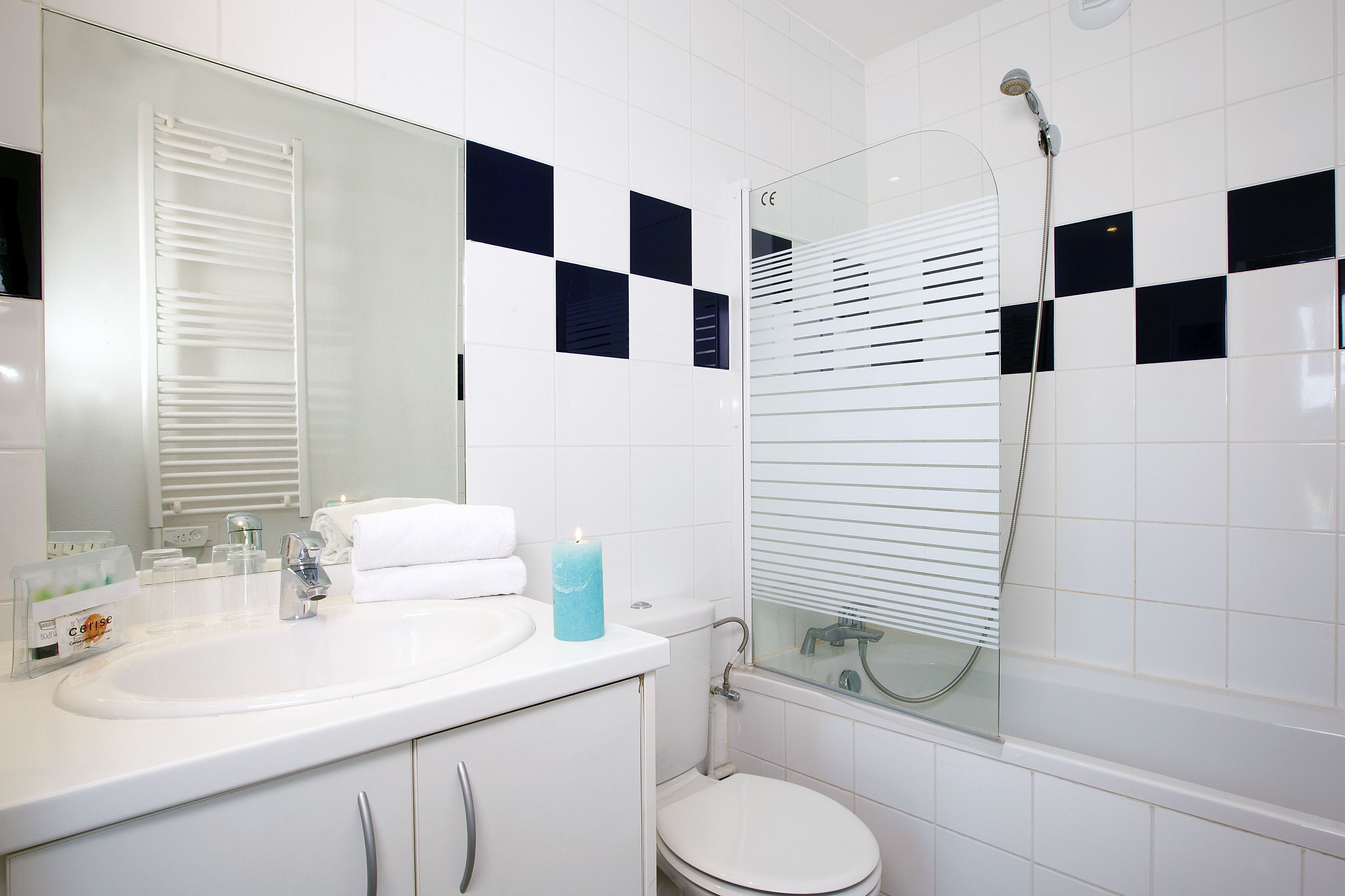 Een moderne badkamer met een wit wastafelmeubel, spiegel en een douchecabine met glazen wanden.