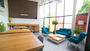 A modern interior with a wooden table, blue chairs, a sofa, and a coffee table. - Cerise Strasbourg (Strasbourg)