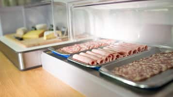 A buffet with various food items including sliced meats and cheeses.