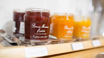 Muestras de frascos de miel con etiquetas, dispuestas en una estantería de madera.