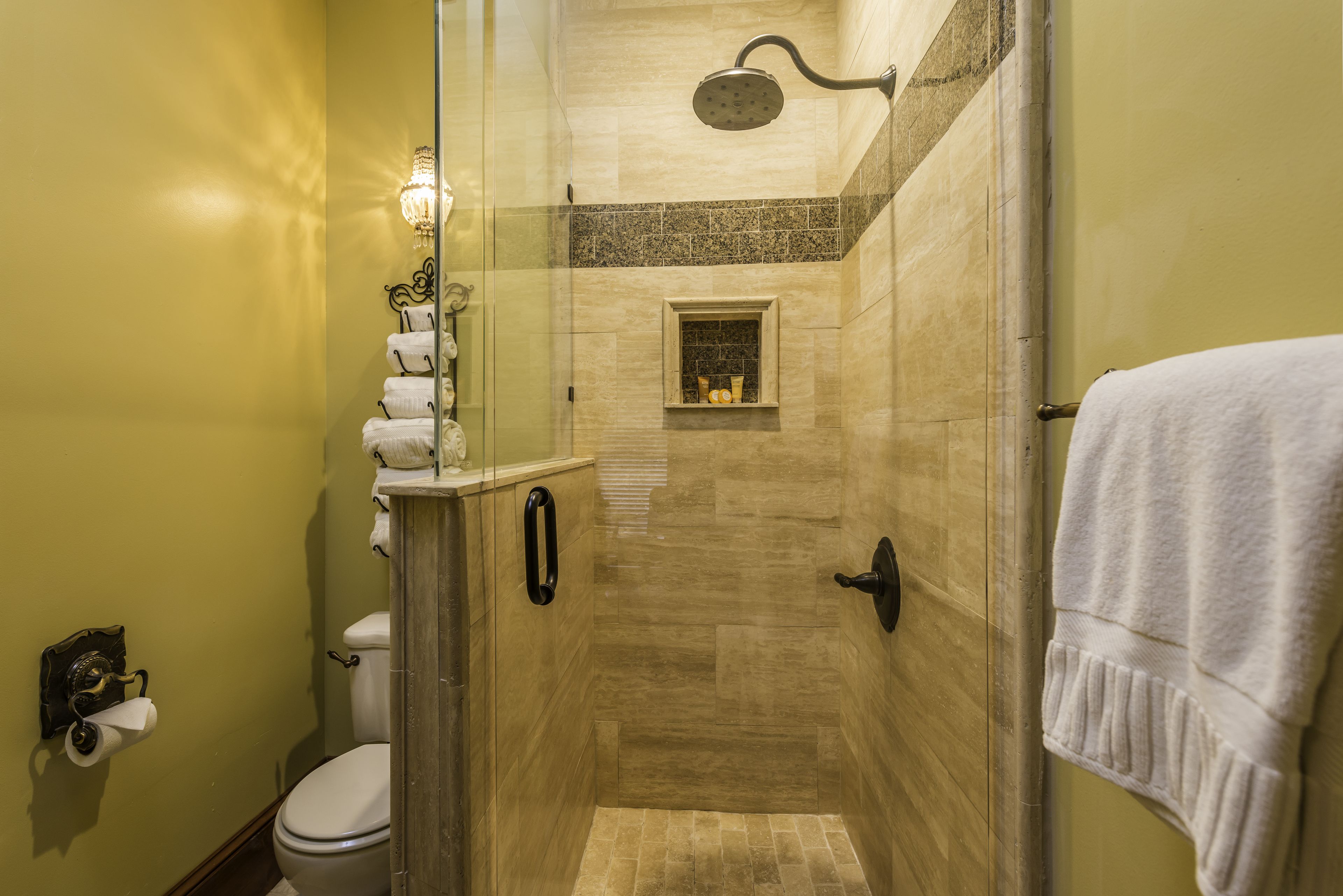 Une salle de bain avec une douche à parois de verre, des toilettes et un lavabo équipé d’un porte-serviettes.