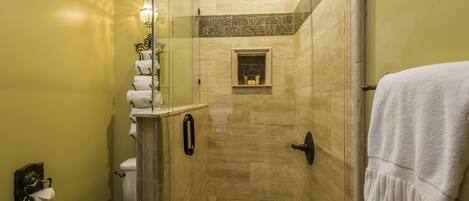 Une salle de bain avec une douche à parois de verre, des toilettes et un lavabo équipé d’un porte-serviettes.