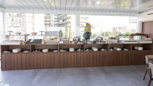 Un buffet de petit-déjeuner moderne, avec des meubles en bois et une grande fenêtre donnant sur la ville.