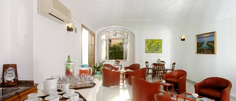 Amplia sala de estar con comedor, sillas de cuero y una mesa de centro.