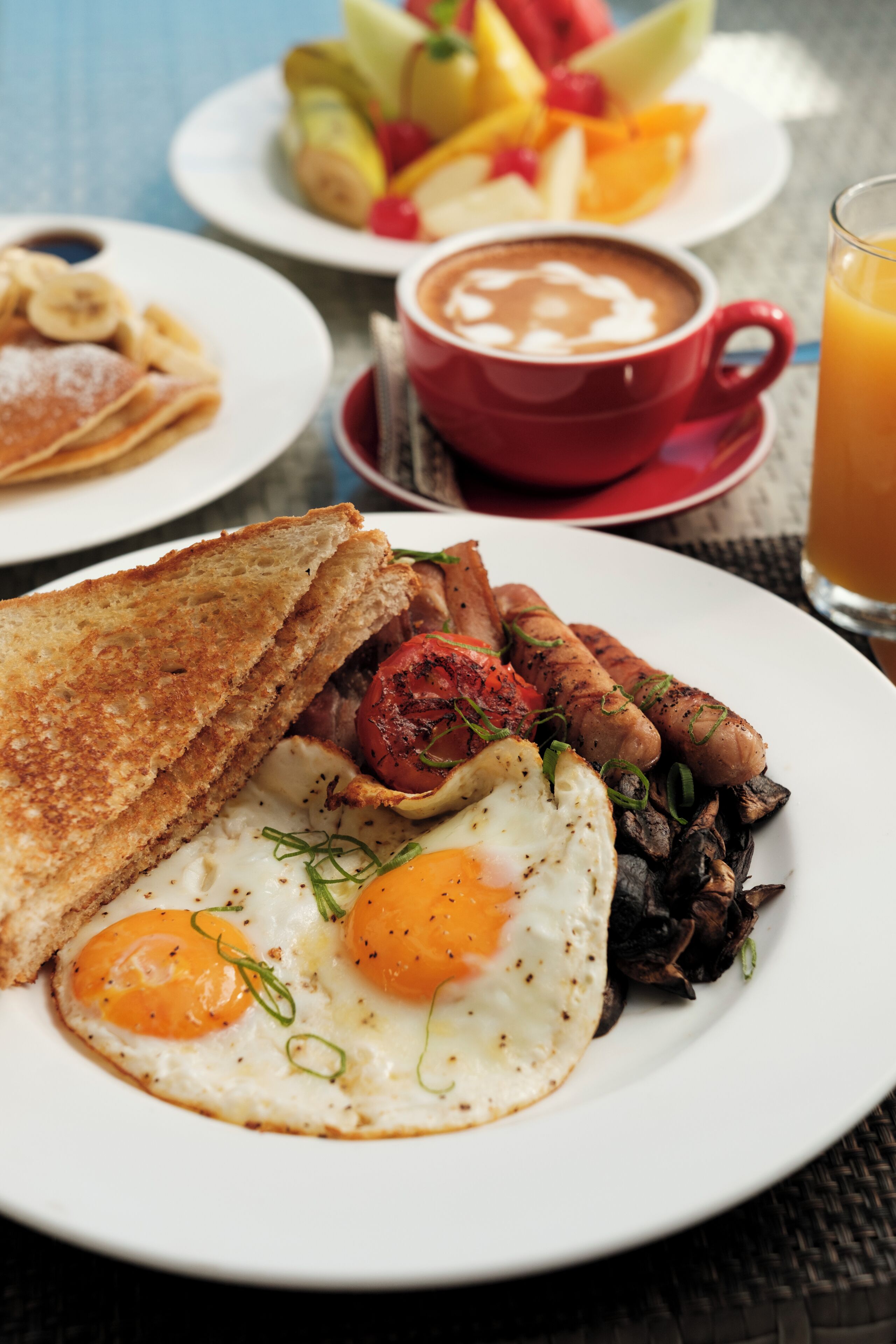 Ein Frühstücksteller mit Eiern, Toast und Würstchen.