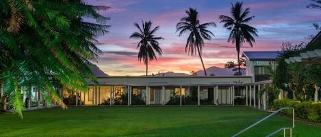 A swimming pool with a clear view of the surrounding landscape, including palm trees and a building with a flat roof.