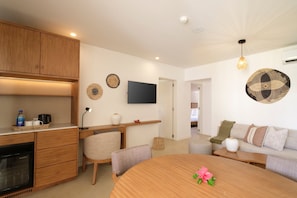 A modern kitchen with wooden cabinets, a built-in oven, and a dining area with a round table and chairs. - Fiji Gateway Hotel (Nadi)