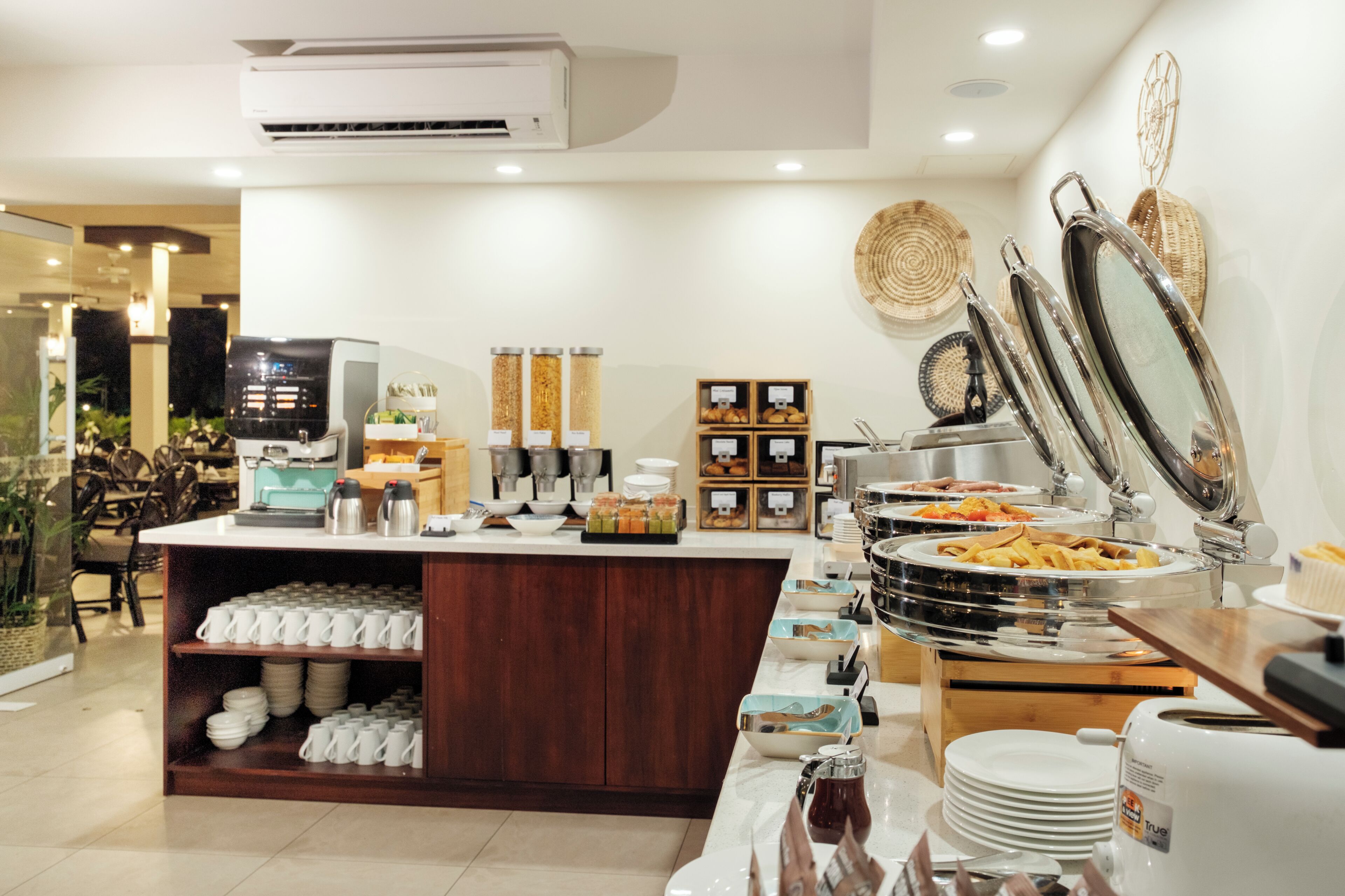 A buffet setup with various food items, a coffee machine, and a coffee station.