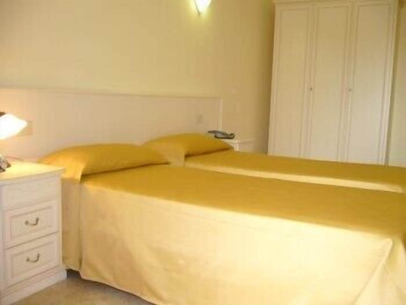 Ett hotellrum med en säng, ett sängbord och en garderob.