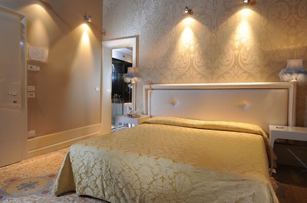Un dormitorio con una cama grande, una mesita de noche, una lámpara y un espejo.