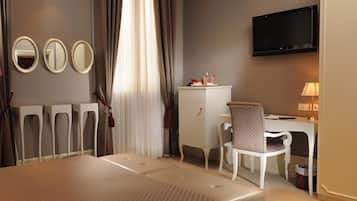 A hotel room with a bed, a desk, a chair, a television, and three mirrors.