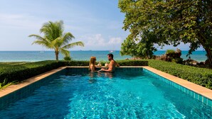 A pool with clear blue water, surrounded by greenery and a view of the sea. - Elixir Koh Yao Yai (Ko Yao)