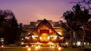 A traditional wooden building with a central entrance, surrounded by a well-maintained lawn and trees. - Elixir Koh Yao Yai (Ko Yao)