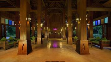 Eine beeindruckende Lobby mit hohen Decken, Holzsäulen und einer zentralen Rezeption.