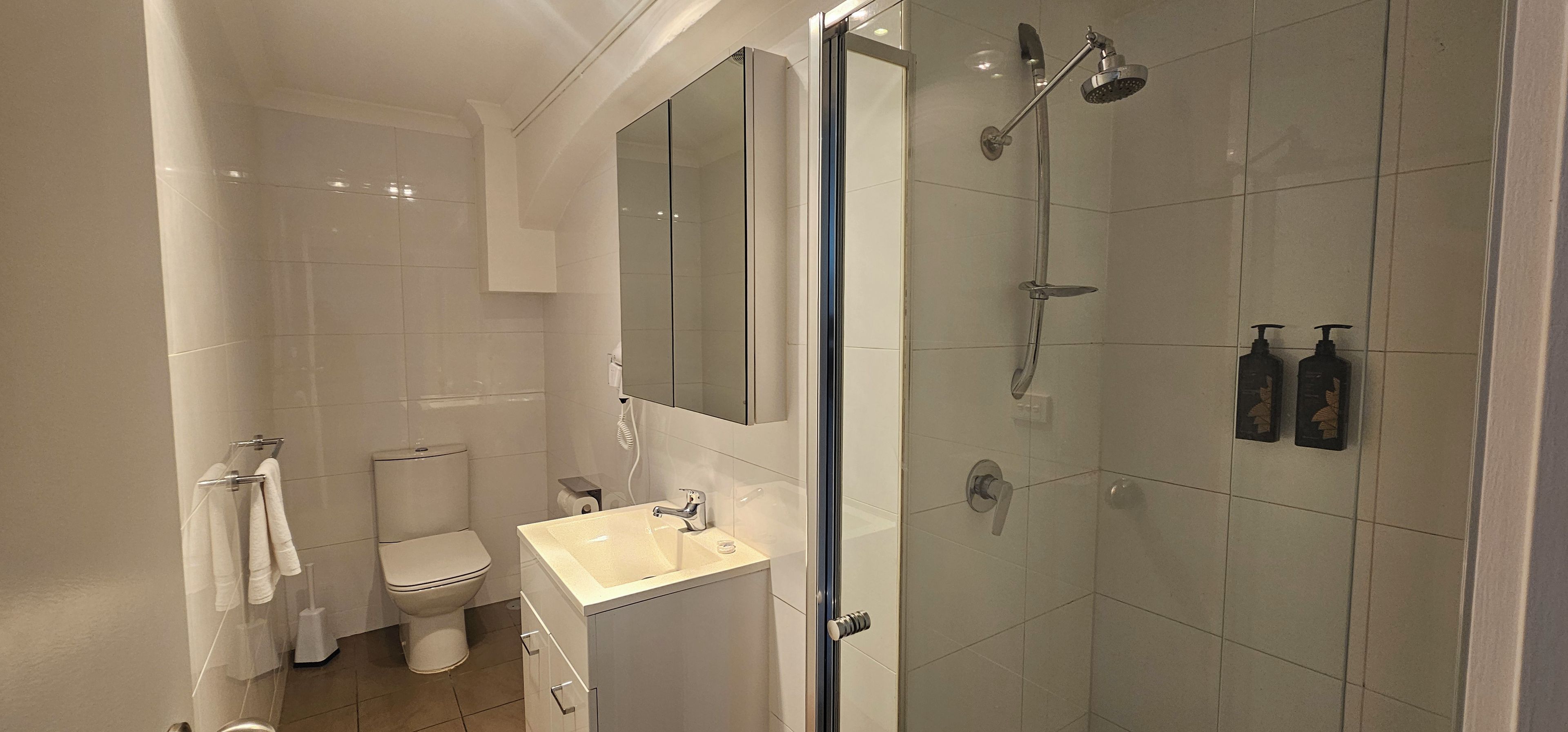 A modern bathroom with a toilet, sink, and shower.
