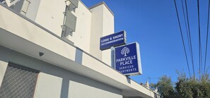 Een gebouw met borden waarop 'LONG & SHORT ACCOMMODATION' en 'PARKVILLE PLACE SERVICED APARTMENTS' staat.