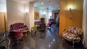A lobby with a reception desk, a staircase, and several seating areas with different styles of chairs and sofas. - Hotel de Cerva (Ribeira de Pena)