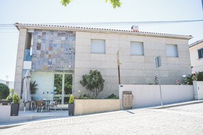 A hotel with a tiled facade, outdoor seating, and a small garden area. - Hotel de Cerva (Ribeira de Pena)