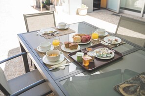A breakfast table with various food items, a glass of orange juice, and a tray of condiments. - Hotel de Cerva (Ribeira de Pena)