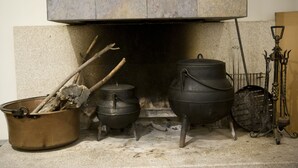 A fireplace with two pots and a metal container.