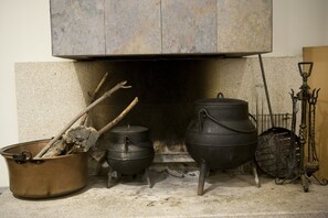 Une cheminée avec deux pots et un récipient en métal.