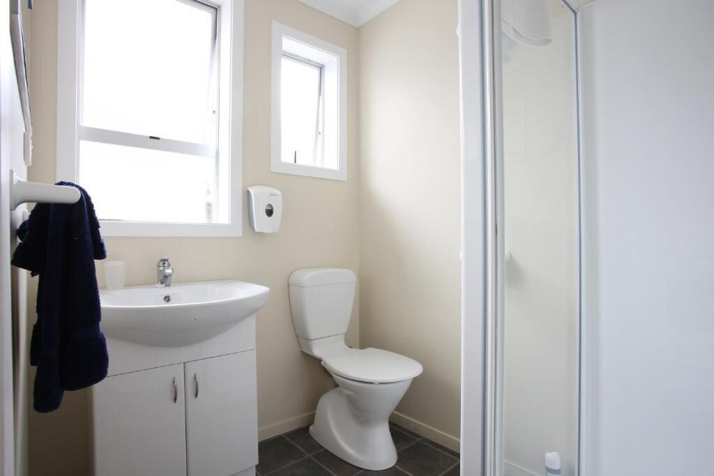 A bathroom with a white sink, a toilet, and a glass shower enclosure.