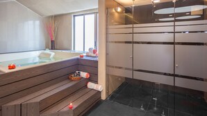 Et moderne badeværelse med træbænk, glasbrusekabine og badekar.