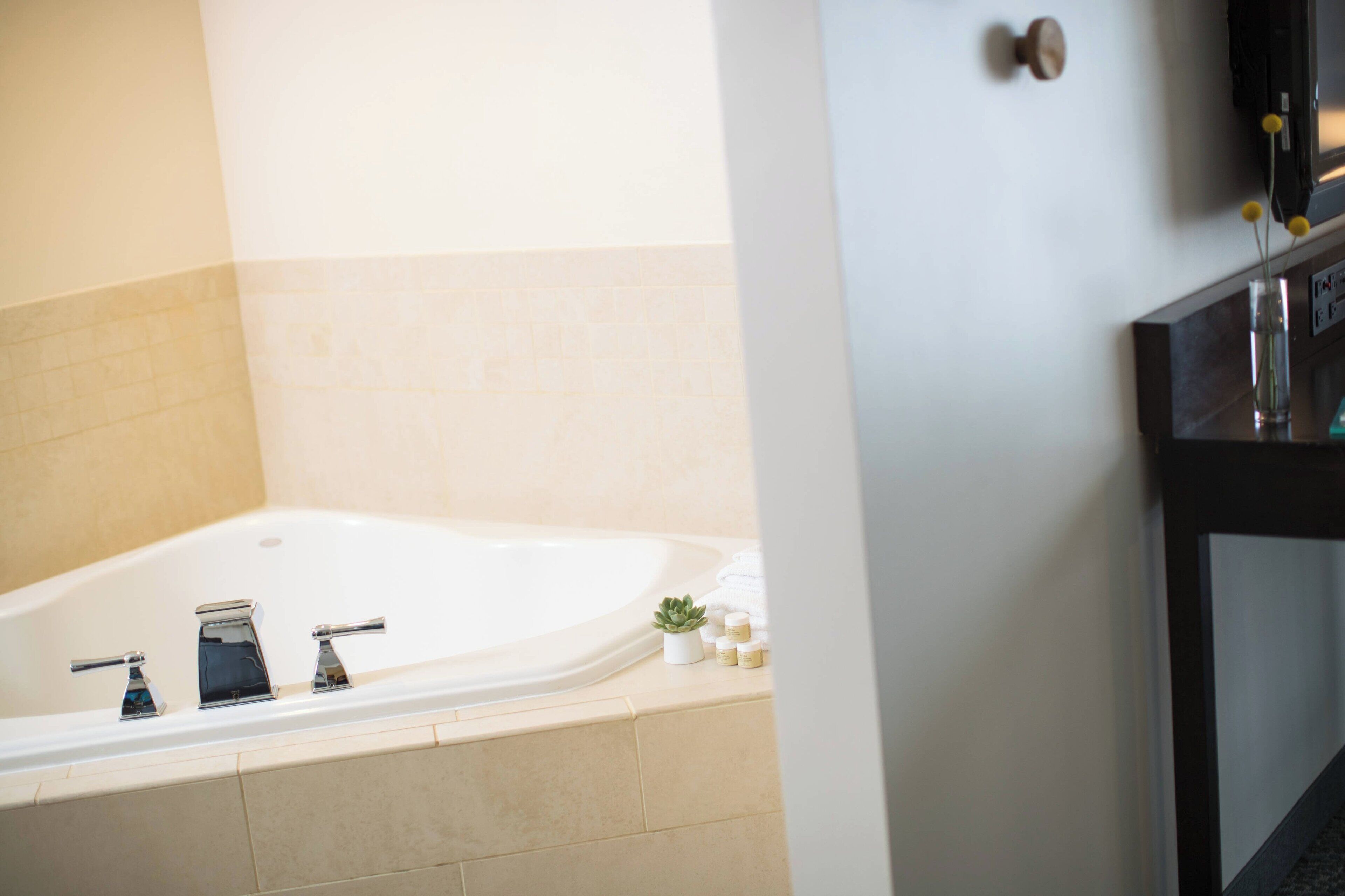 Une salle de bain avec une baignoire, un lavabo et un miroir.