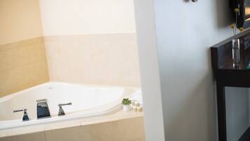 Une salle de bain avec une baignoire, un lavabo et un miroir.