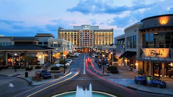 A Renaissance Hotel with a central fountain, surrounded by shops and parked cars.