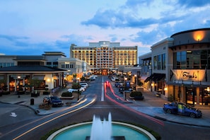 A Renaissance Hotel with a central fountain, surrounded by shops and parked cars.