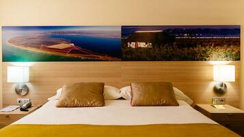 Una habitación de hotel con una cama grande, dos lámparas de noche y dos mesitas de noche.
