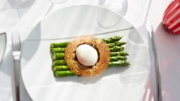 Un plato con un huevo pochado sobre espárragos, servido en un plato blanco.
