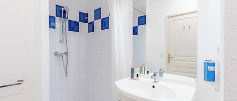 A modern bathroom with a shower, a sink, and a mirror.