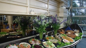 Une table de buffet garnie de divers plats et agrémentée de décorations florales.