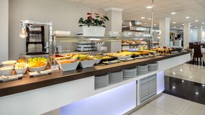 A buffet with various food options, a coffee machine, and a potted plant. - Hotel RH Gijón By Hoteles RH (Gandia)