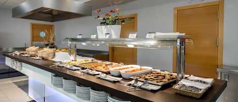 A buffet setup with various food items, a flower arrangement, and a private room sign.
