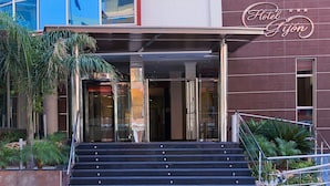 A hotel entrance with a modern facade, a staircase leading up to the entrance, and a sign indicating the hotel name. - Hotel RH Gijón By Hoteles RH (Gandia)