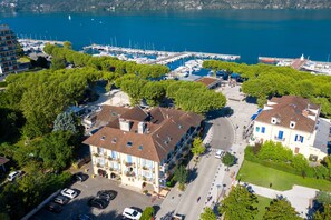 An aerial view of a marina with boats, a parking area, and buildings with balconies. - The Originals City, Hôtel L'Iroko (Aix-les-Bains)