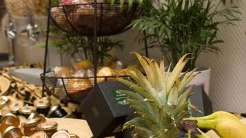 Une table avec différents fruits, un ananas et des pots de confitures.