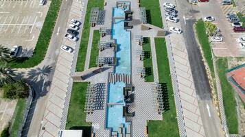 Vista aérea de un estacionamiento con piscina central, rodeado de zonas de estar y áreas verdes.