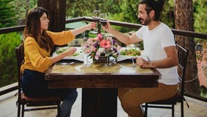 A couple dining at an outdoor table with a wooden pergola overhead, surrounded by greenery. - Loto Azul Resort and Spa (Valle de Bravo)