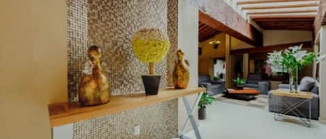 A modern interior with a wooden console table, decorative vases, and a textured wall.