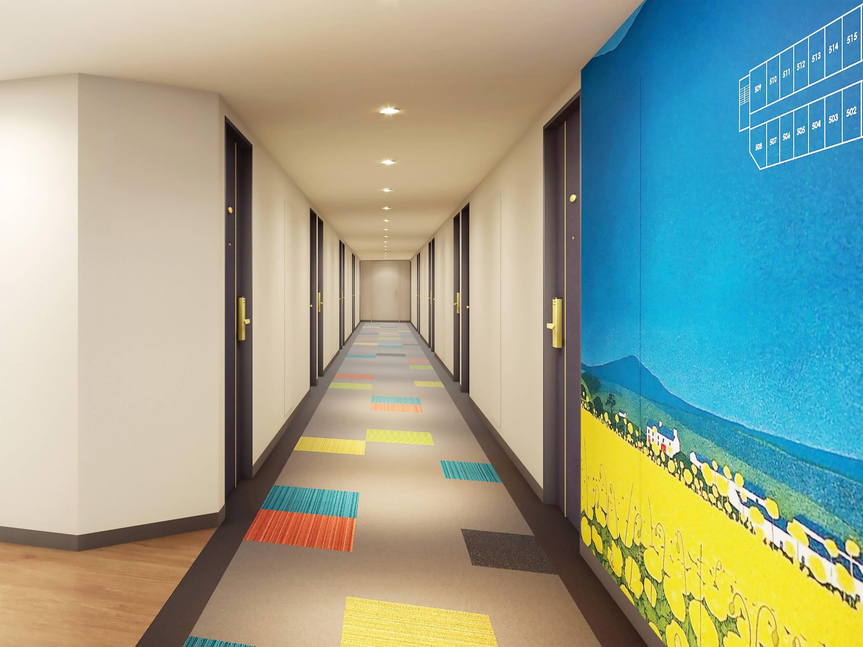 A long, narrow hotel corridor with a colorful carpet, doors on both sides, and a mural on the right wall.