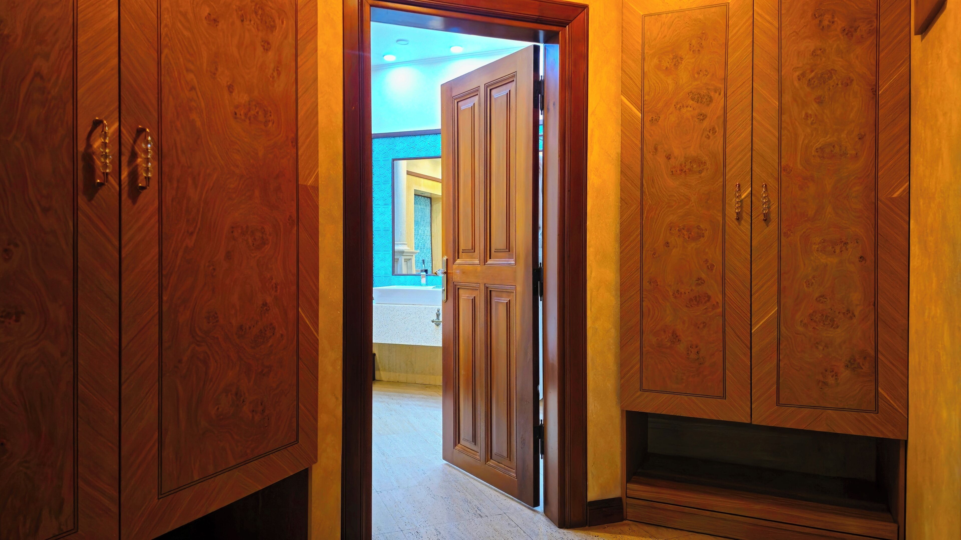 Ein Holzschrank mit Spiegel und einer Tür zum Badezimmer.