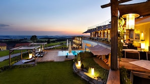 A hotel with a pool, outdoor seating, and a view of the countryside. - Revita Hotel Kocher (Sankt Agatha)